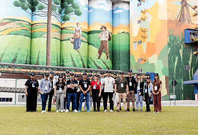 pessoas posando para um foto em frente ao silos da Maltaria Campos Gerais