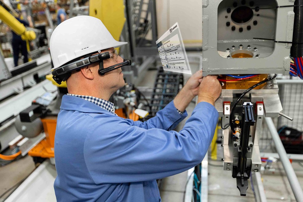 A photo of a frontline worker wearing a RealWear headset and getting augmented reality guidance to do his job