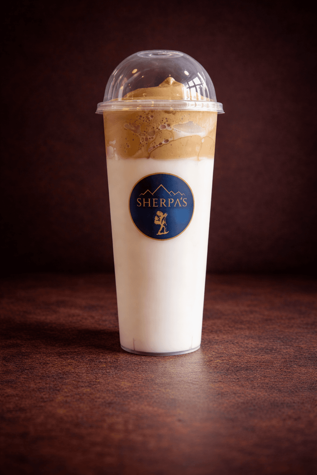 Dalgona Whipped Coffee in a Café Sherpa's branded cup at Brookfield WI café. Toffee-colored South Korean whipped coffee poured over chilled milk.
