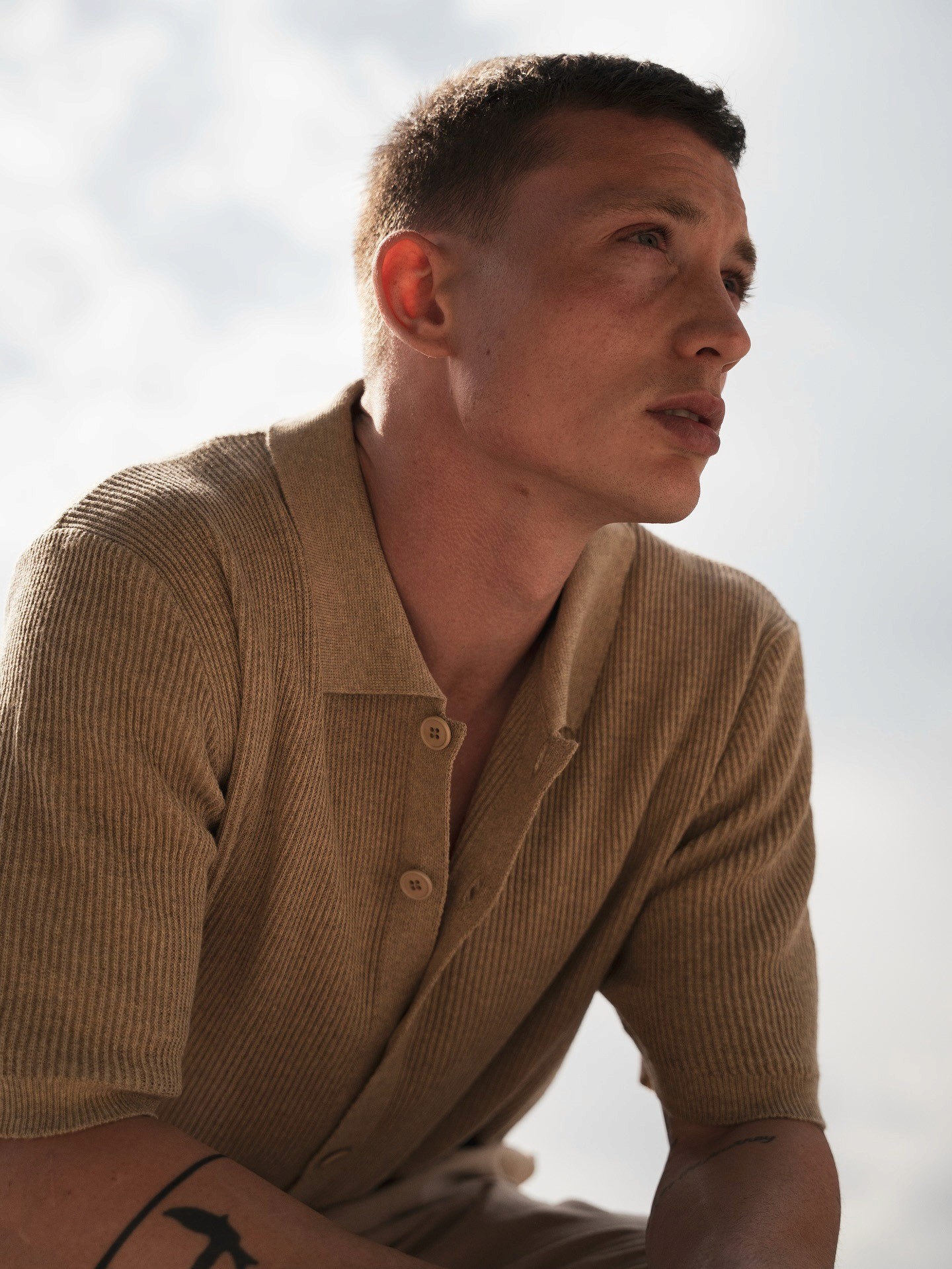 Plan rapproché du mannequin homme du lookbook FW25 deWooden Store, marque Italienne masculine, portant un pull à col polo