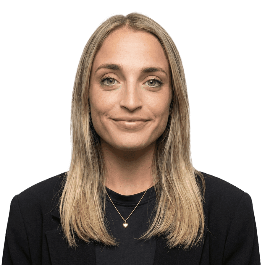 Blonde woman in a black blazer and necklace smiling.