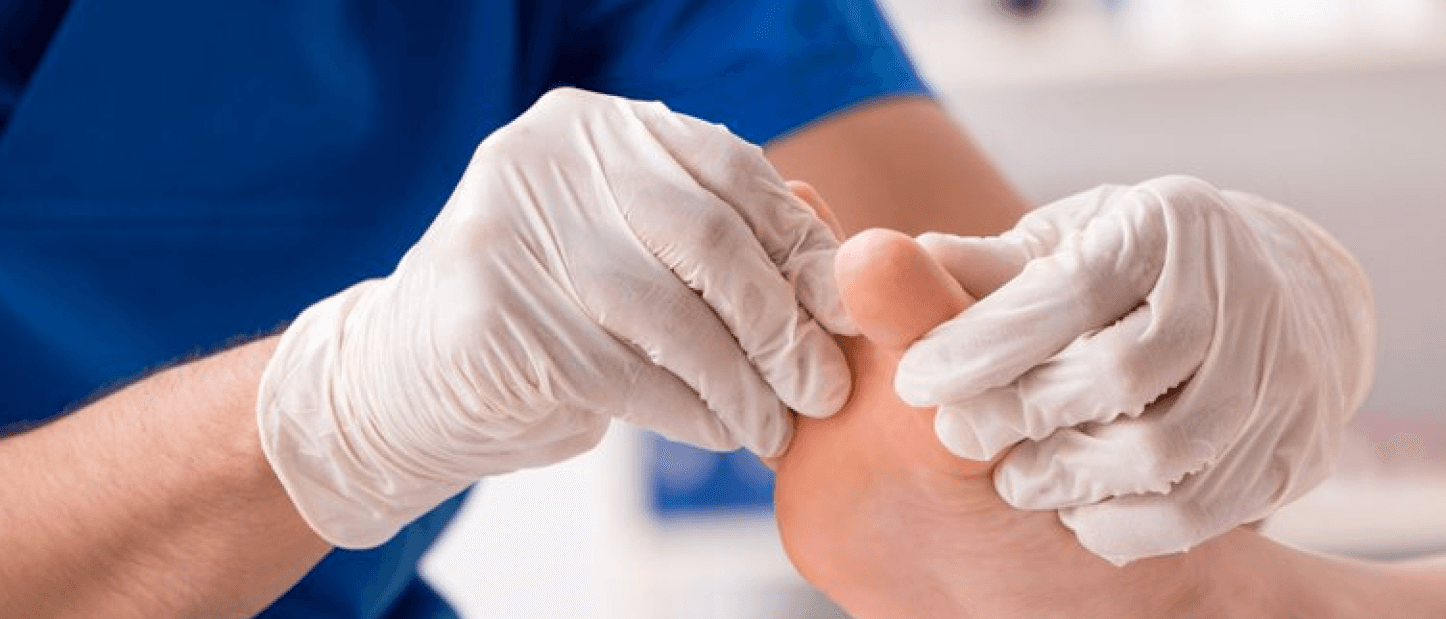 Doctor performing a foot diagnosis on a patient, scrubs and gloves are on