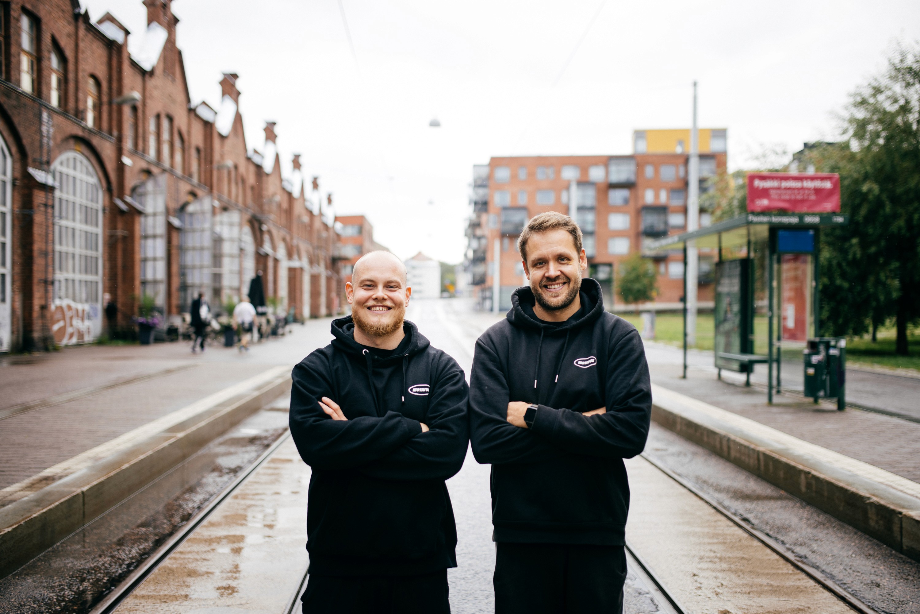 Motivuksen perustajat hymyilevät Motivus Vallilan kuntosalin ulko-oven luona