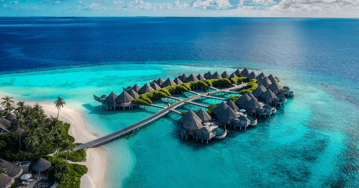 Aerial view of an resort above clear turquoise water connected by wooden walkways
