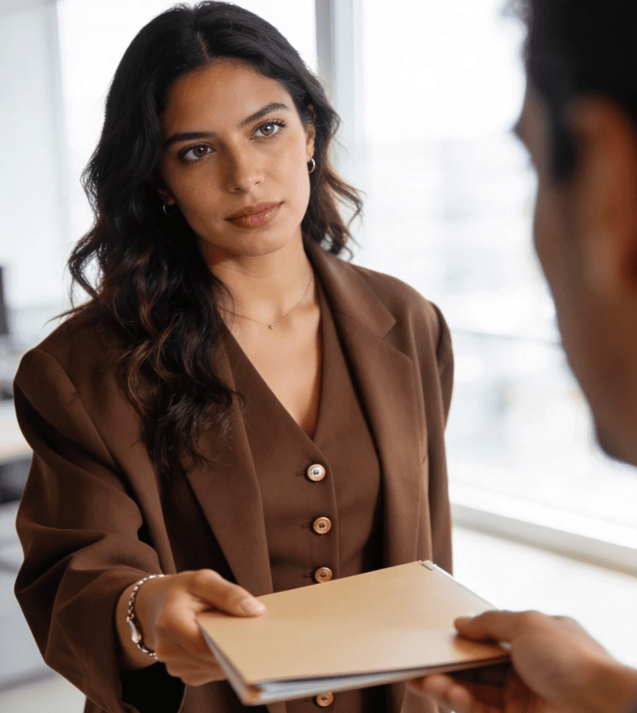 Woman handing a folder to a colleague.