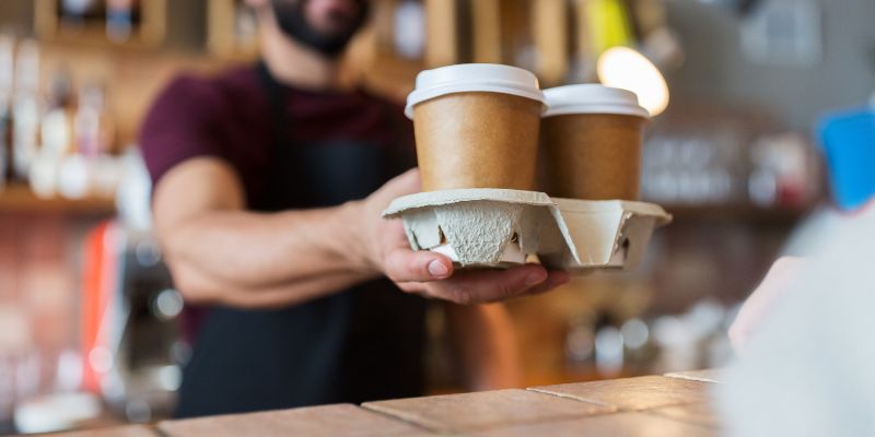 A Malaysian F&B business staff serving coffee to his customer