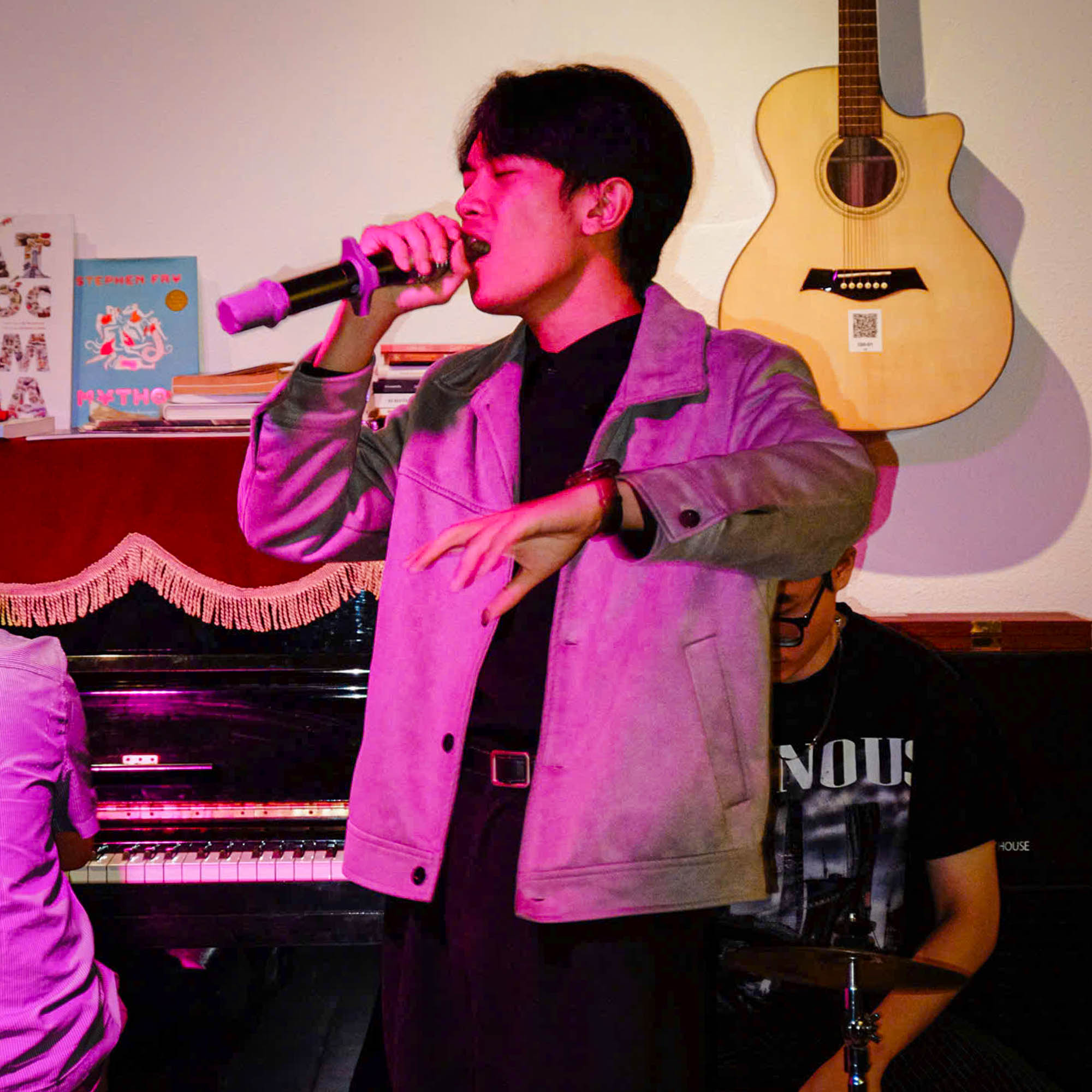 Keyboardist singing, silhouetted by bright orange light
