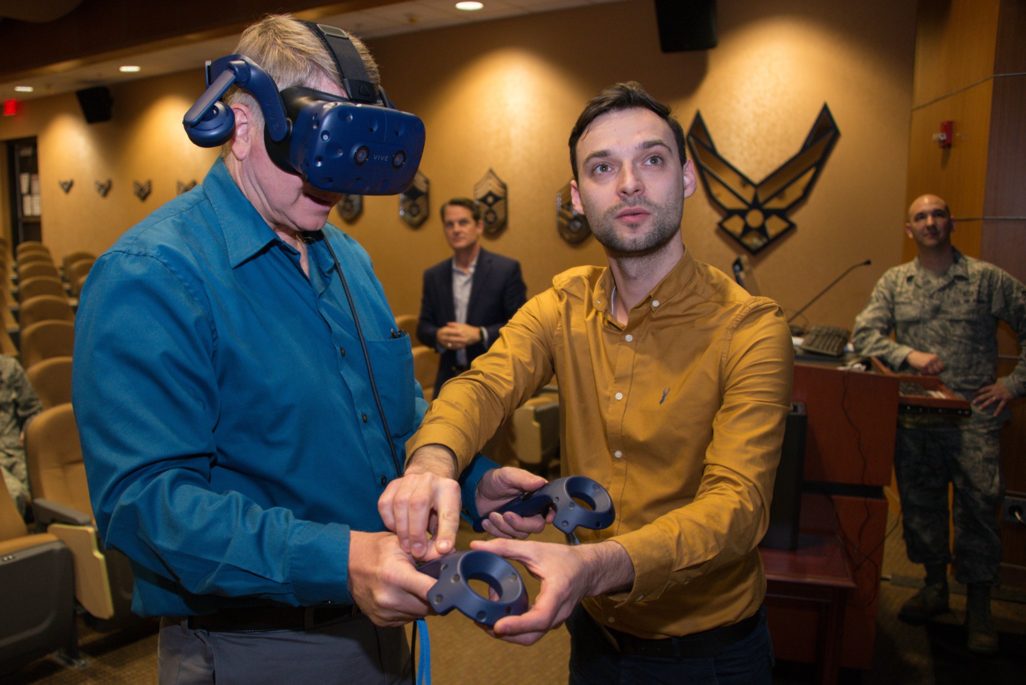 Man in yellow teaching military how to use new VR Training