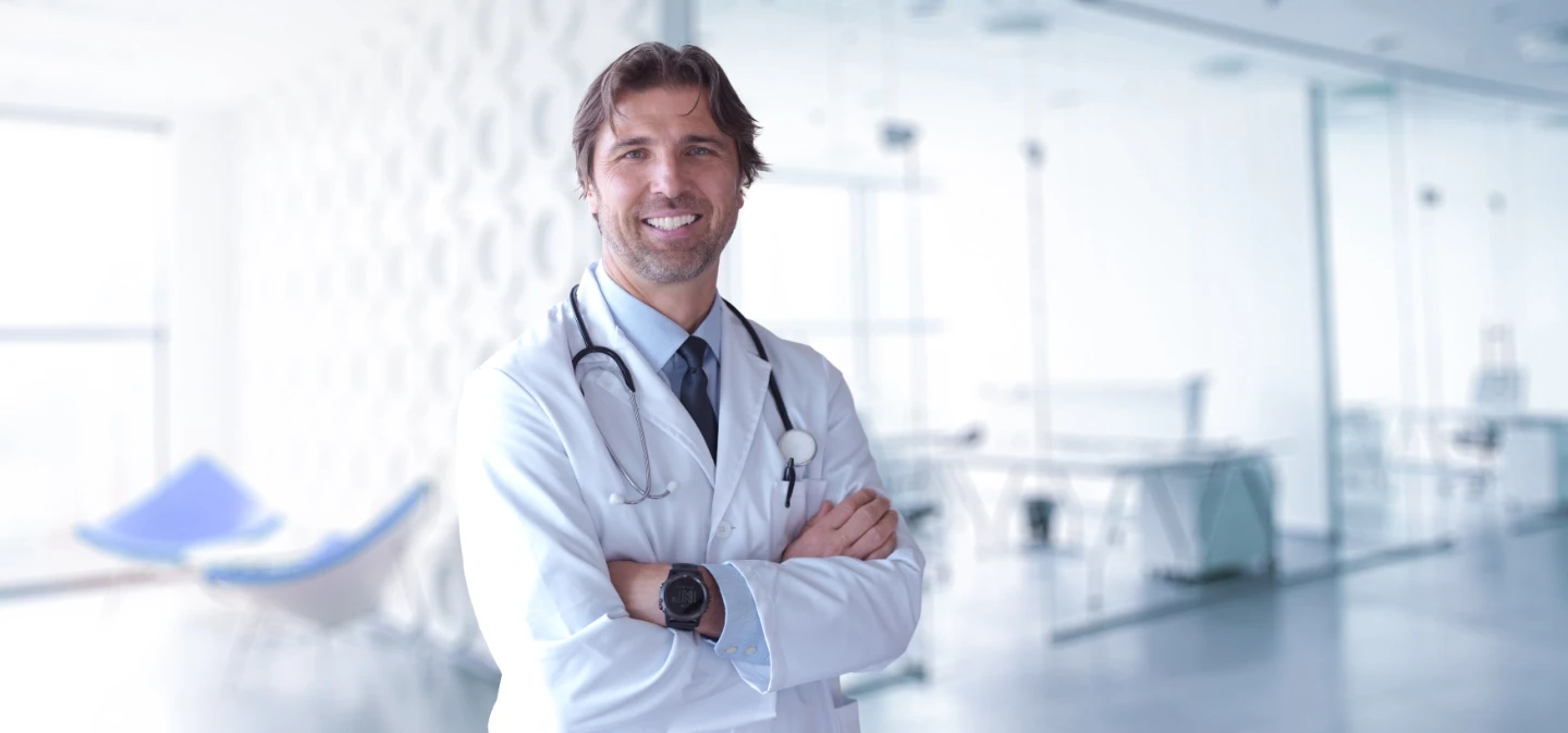Male doctor with arms folded looking at the camera