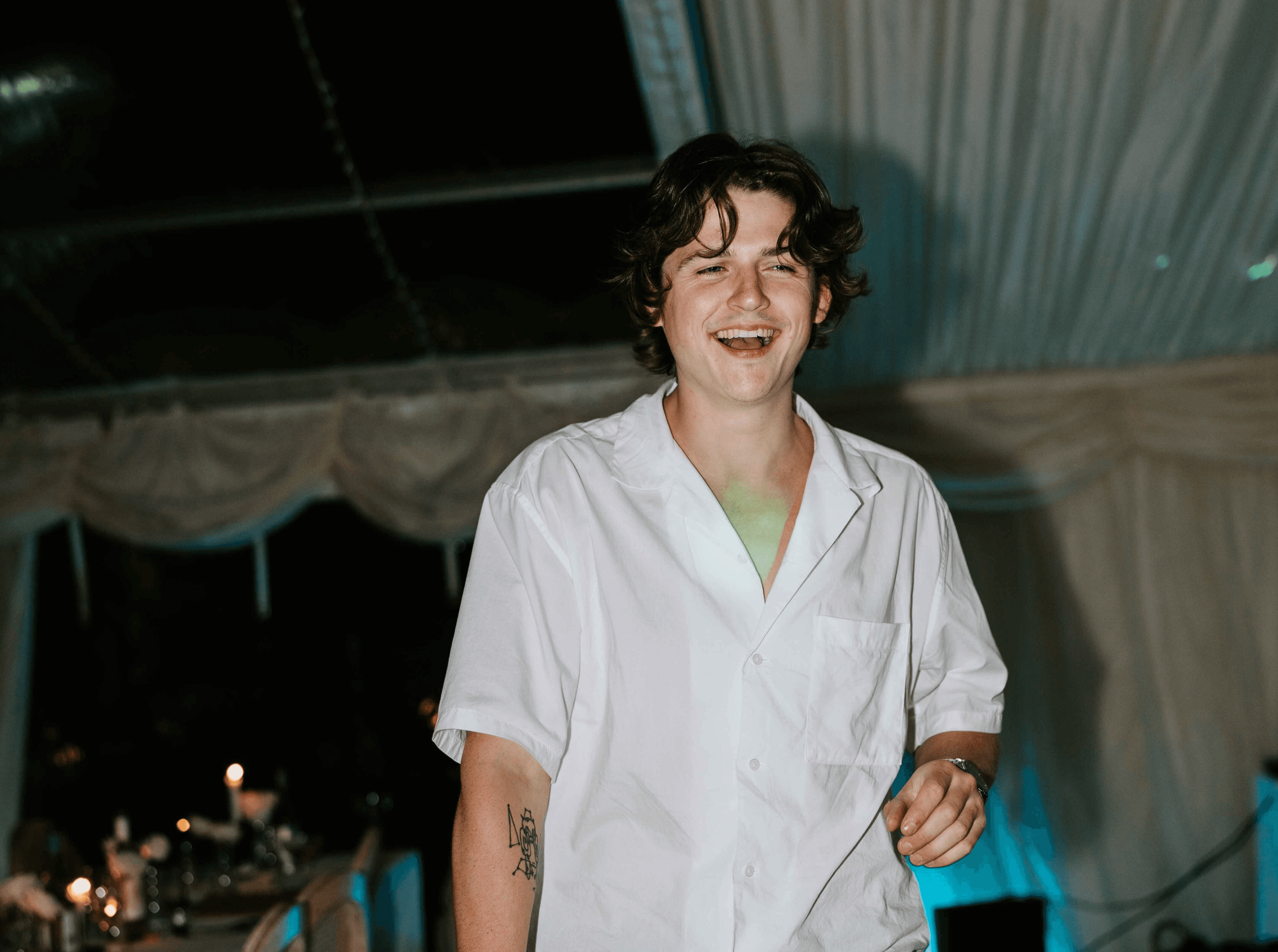 Wedding videographer enjoying the evening reception, captured candidly on the dance floor while holding a camera