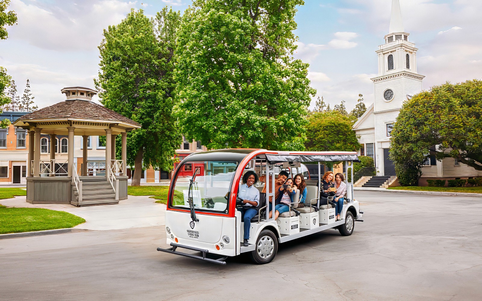 Tourists on a tram at Warner Bros. Studio, Los Angeles, with film set backdrop.