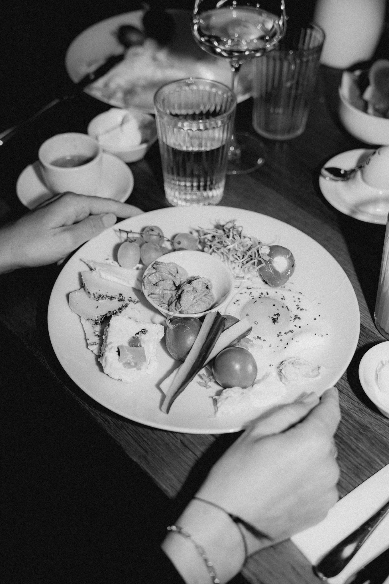 Schwarz-Weiß-Fotografie eines Frühstückstellers mit einer Auswahl an frischen Zutaten, Gemüse und Brot, mit dem Schriftzug 'BREAKFAST'