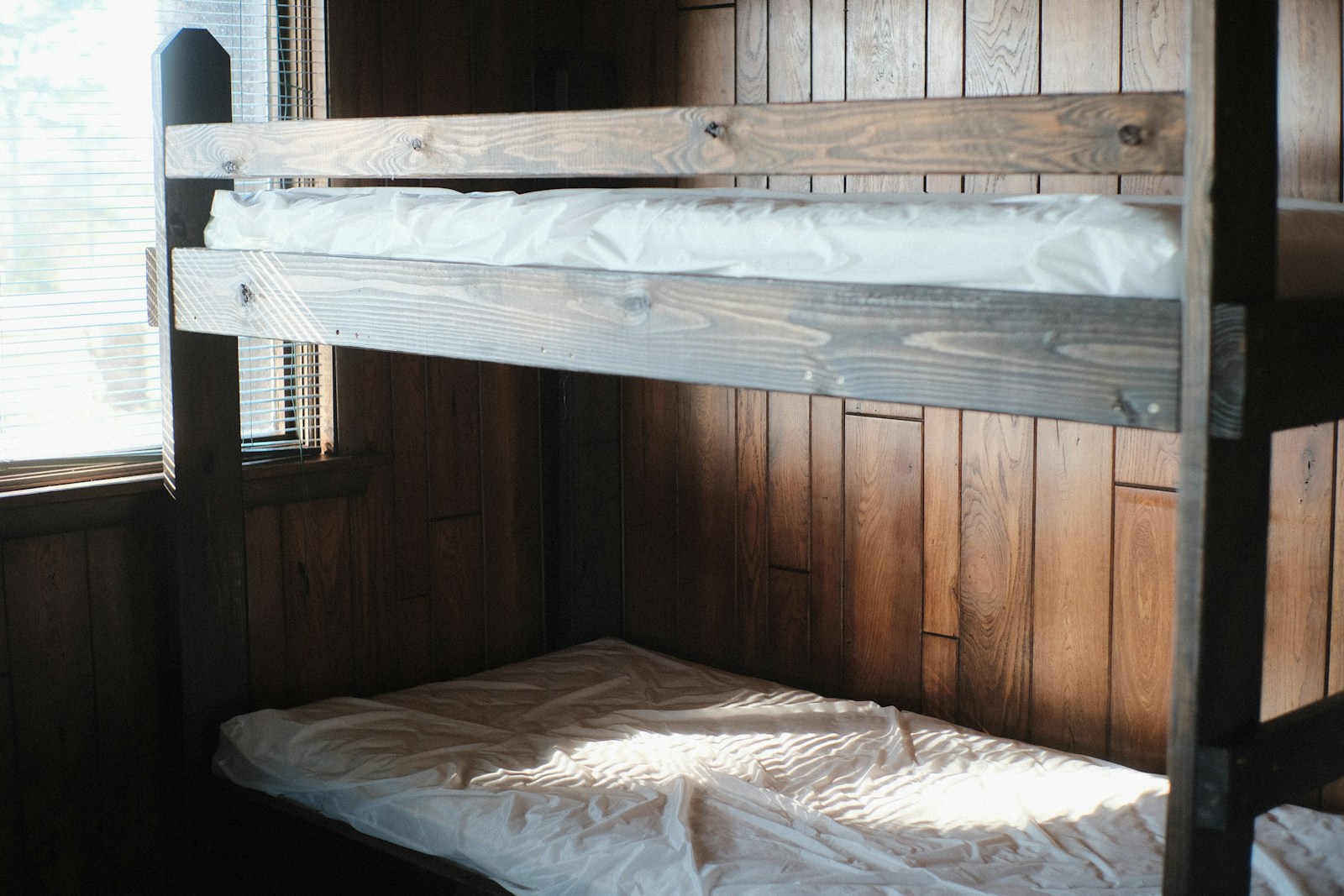 Wooden bunk beds in a small room, shown in red light
