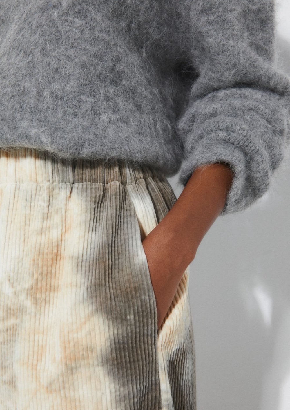Détail de lookbook Rita Row sur une poche de pantalon en velours tye-and-dye et pull ample gris