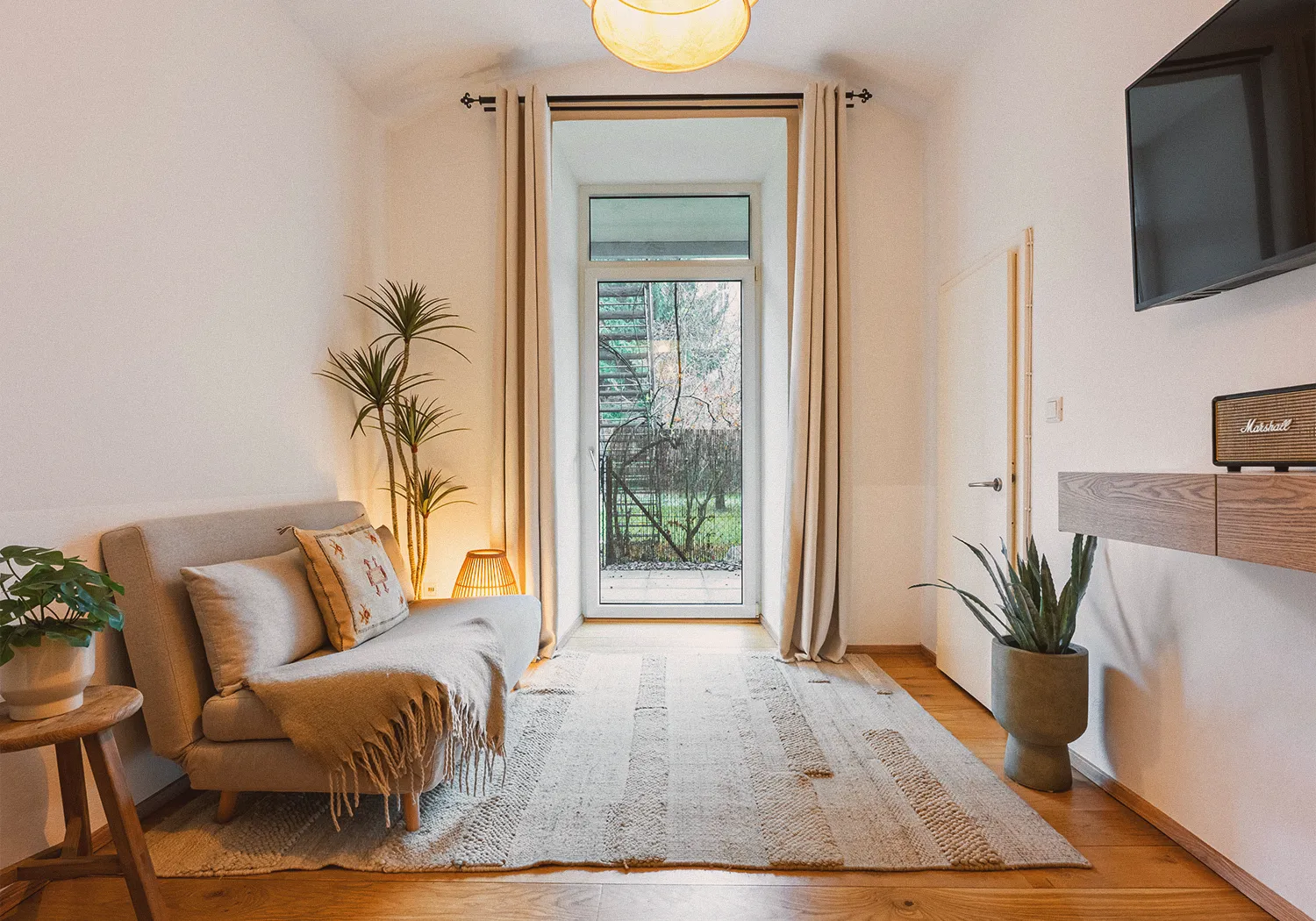 Garden N°1 • living room with a daybed sofa and a glass door to the garden