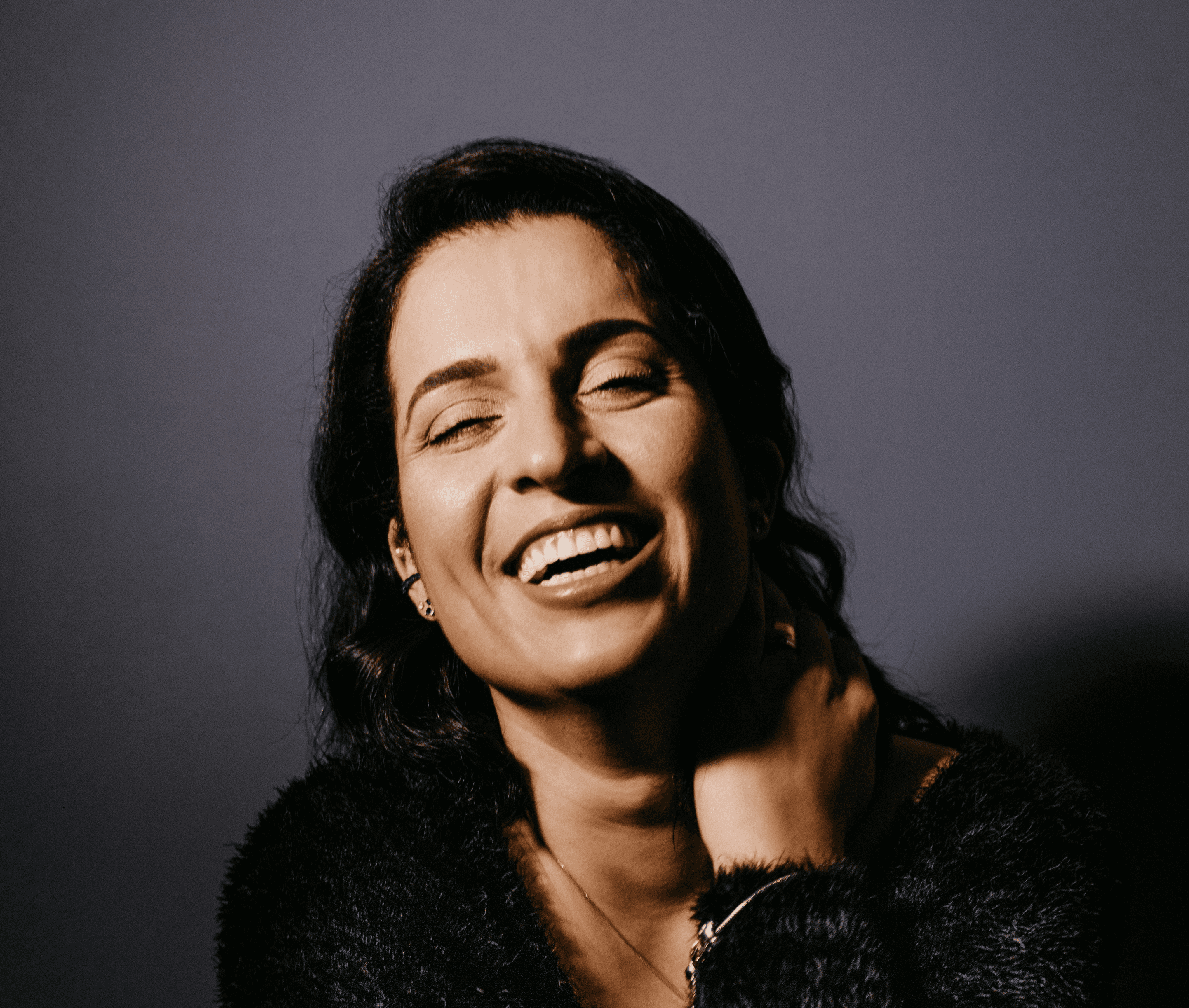smiling woman in black fur coat
