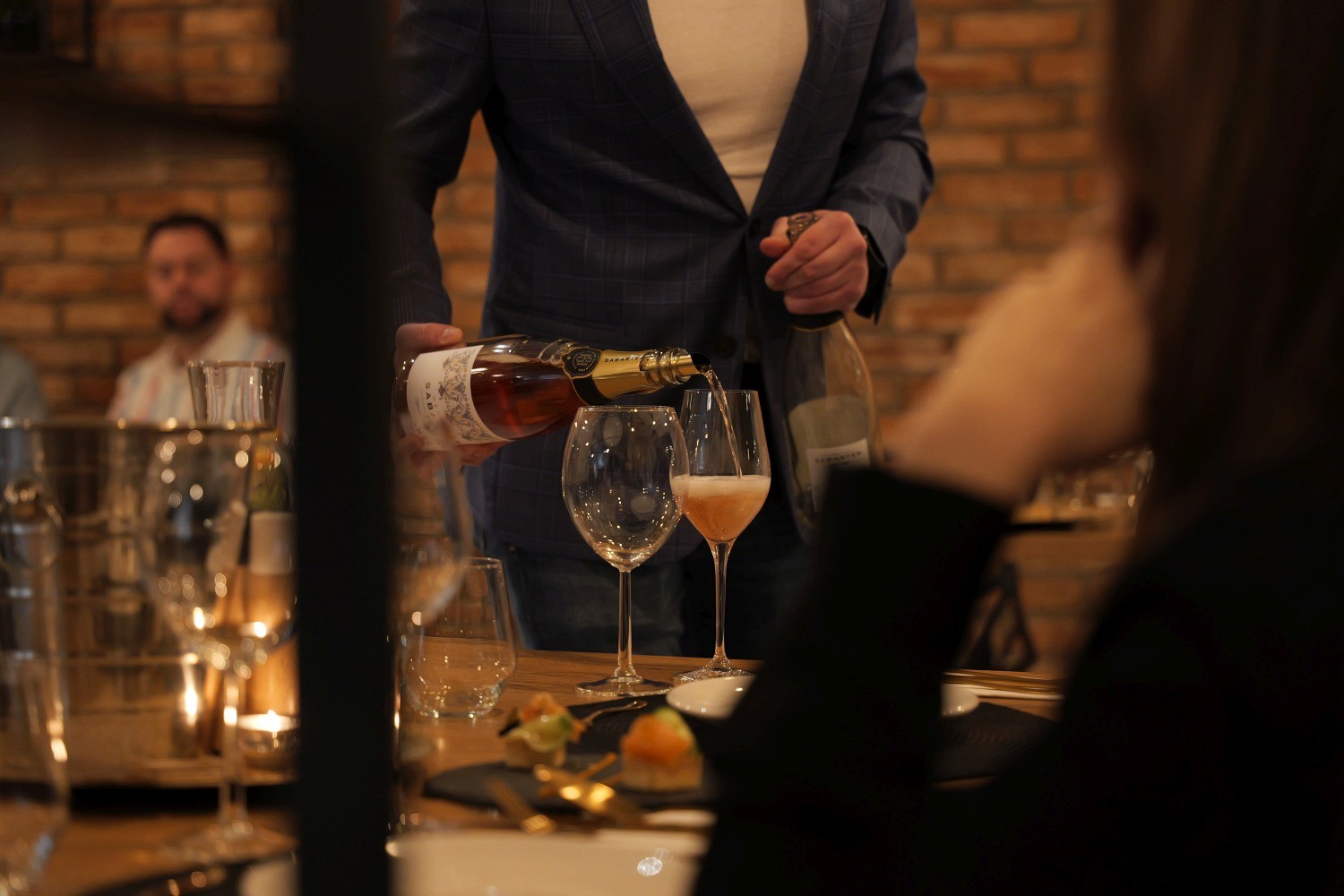 Sommelier nalewający wino musujące podczas degustacji w Niedźwiedzia 25