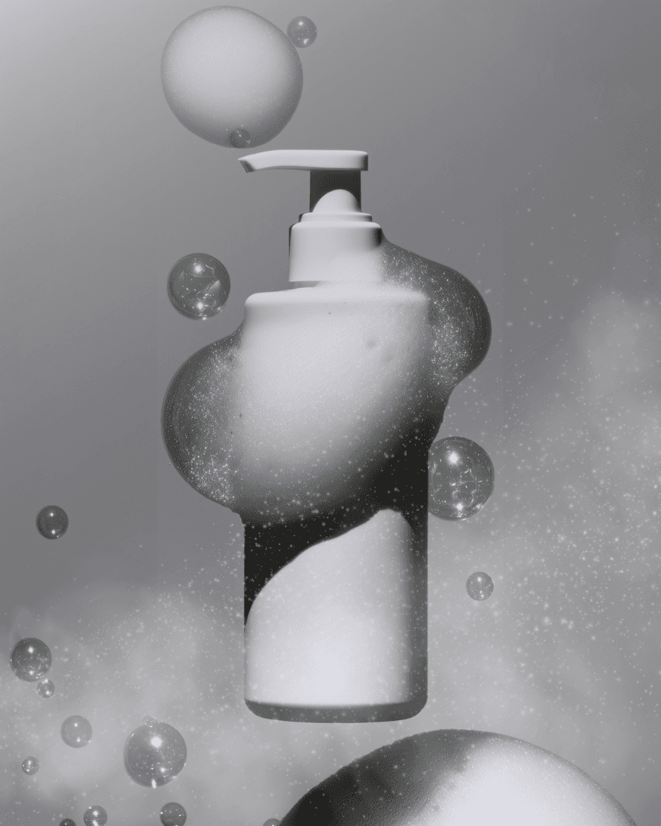 A white pump bottle surrounded by floating soap bubbles and foam, set against a soft gray background for a clean, modern look.