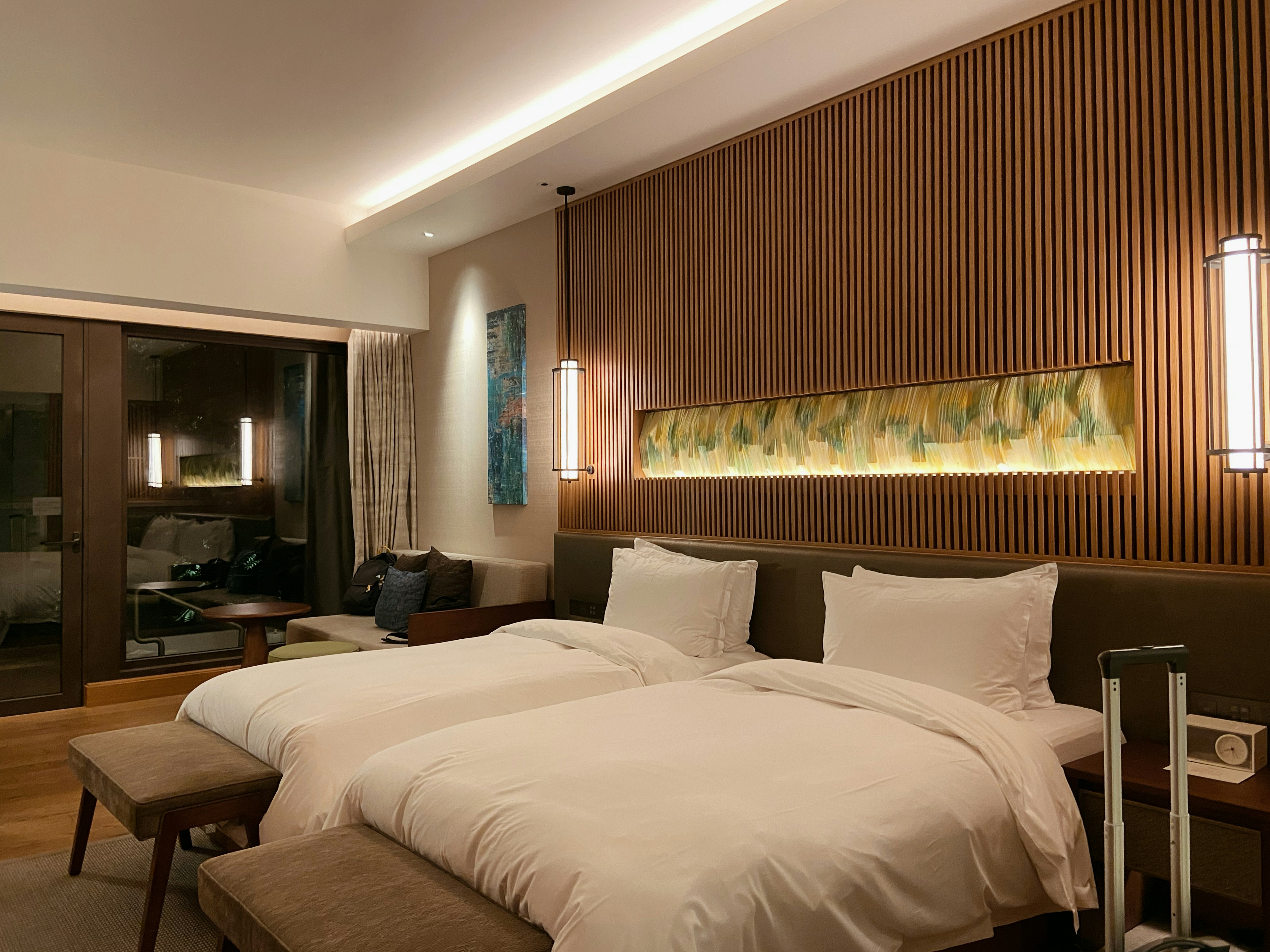 Hotel room with a double bed and single bed for three guests.