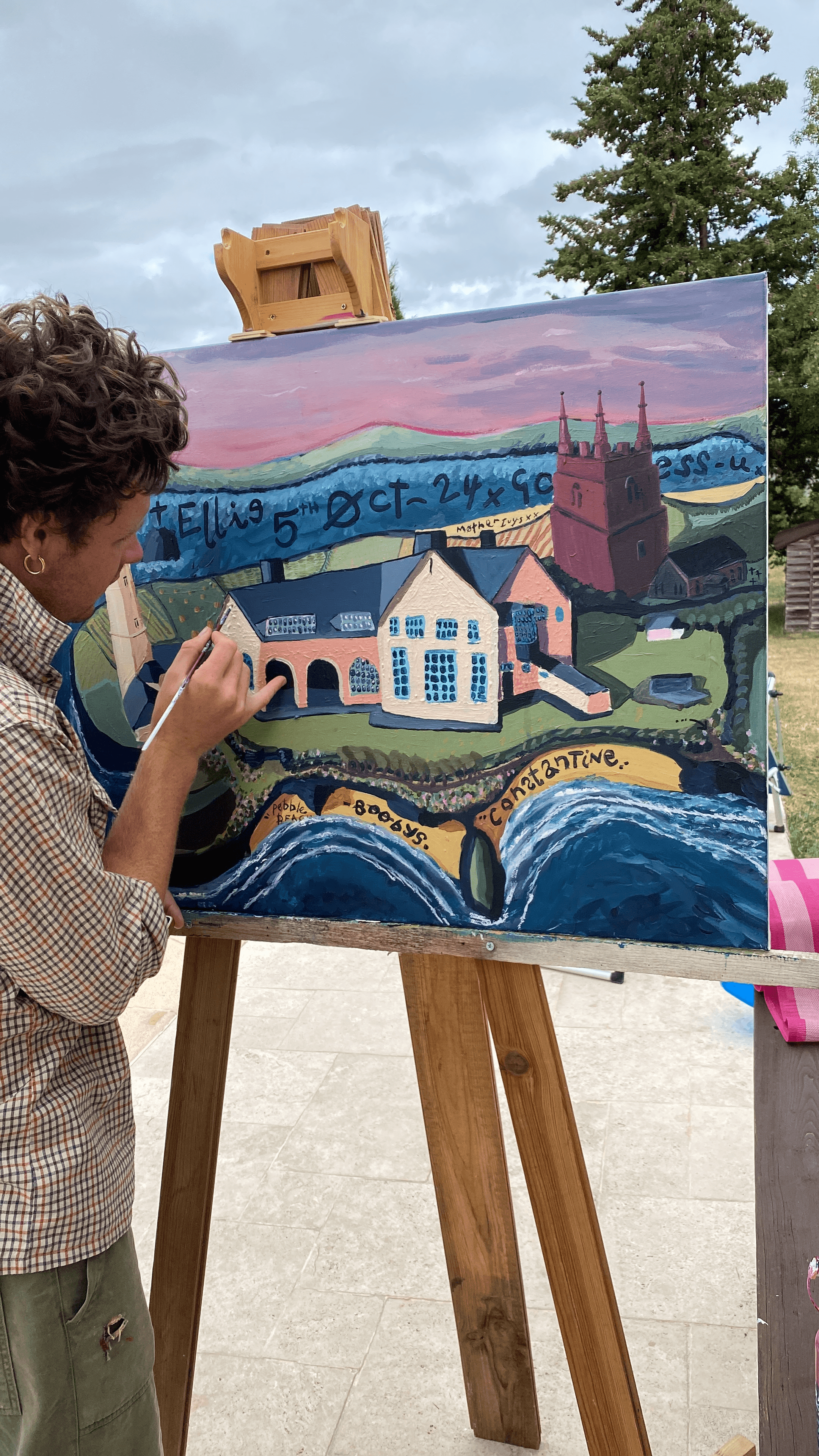 A person painting on a canvas outdoors.