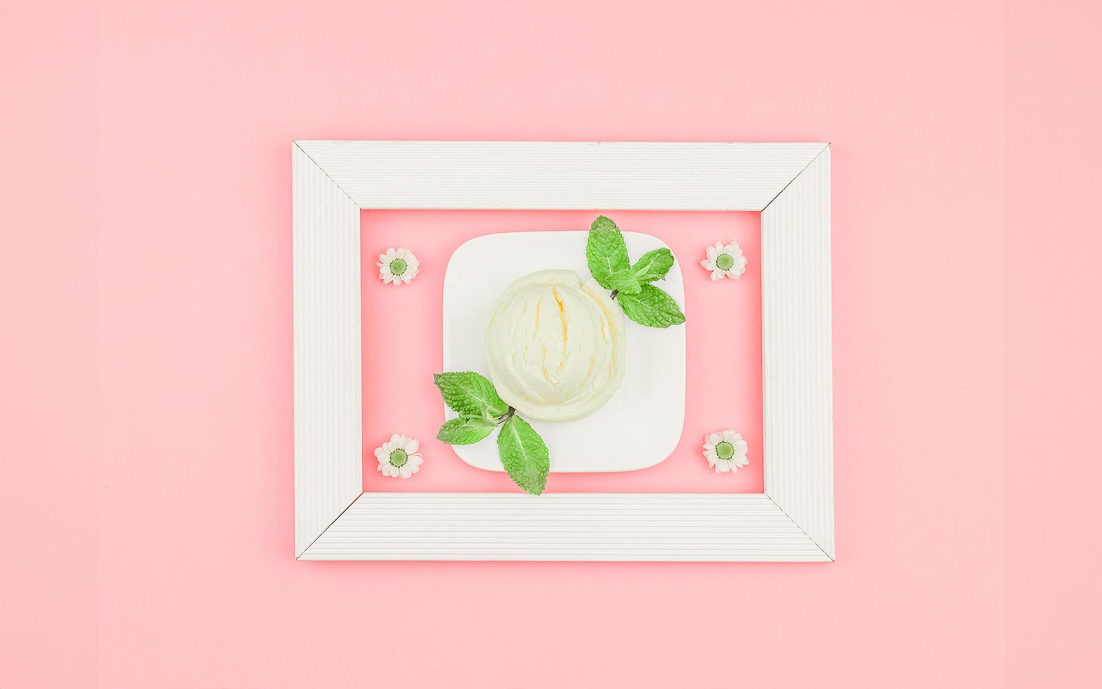 新加坡冰淇淋博物馆展览中的冰淇淋球，配有薄荷叶，摆放在盘子上。