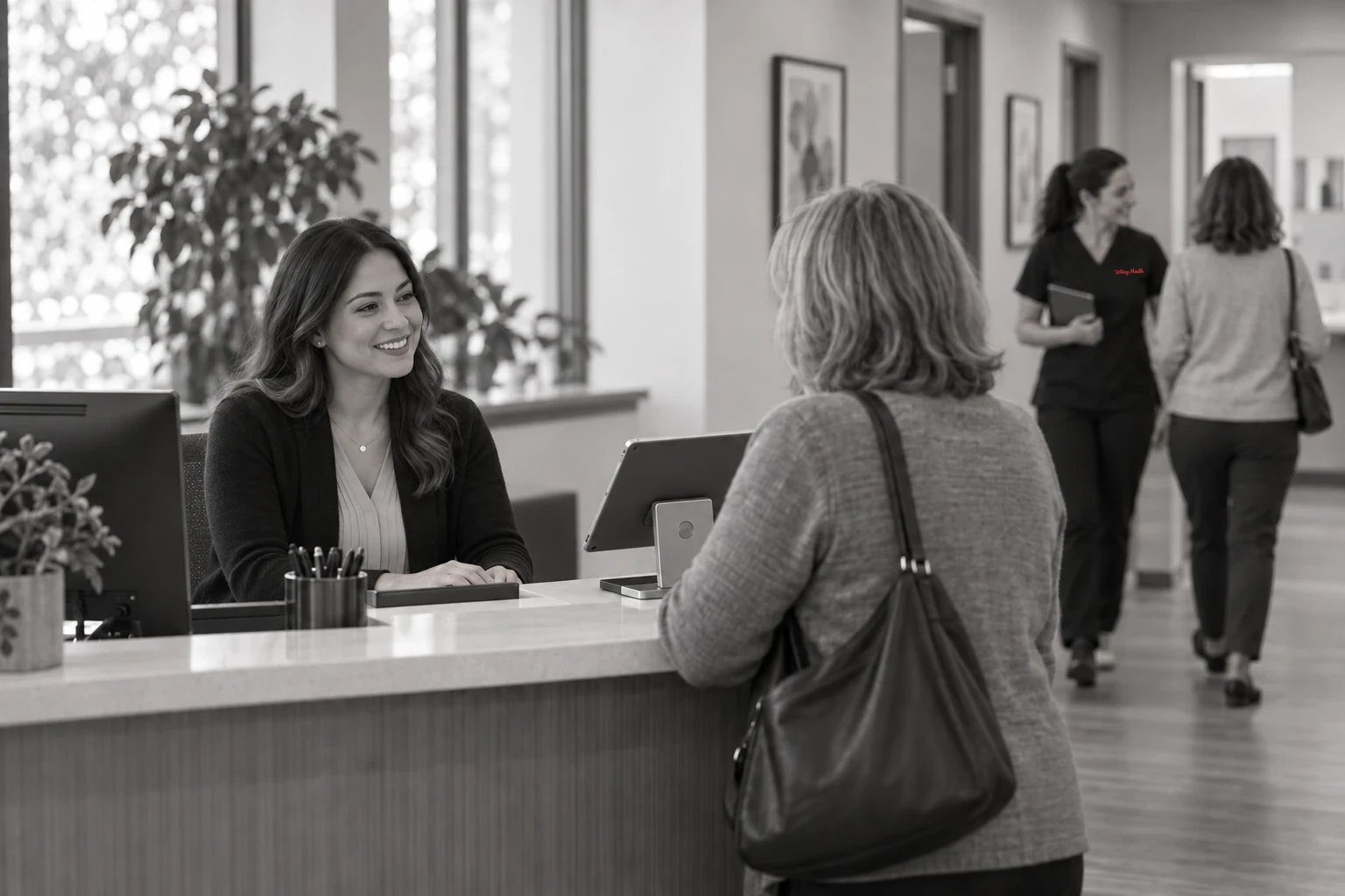 Front desk check-in while a research coordinator walks a study patient to an exam room