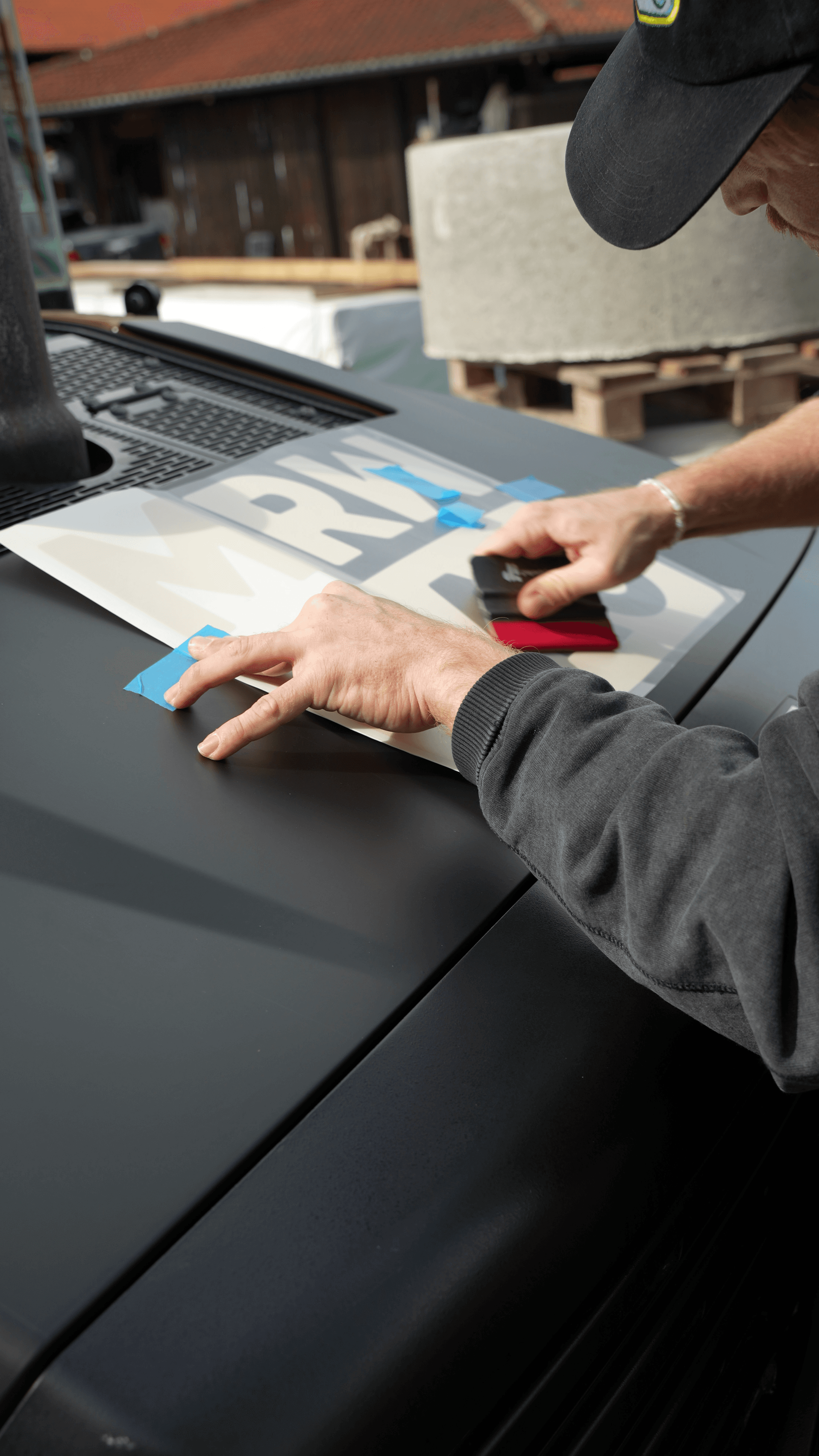 Bagger wird mit Plottschrift beklebt