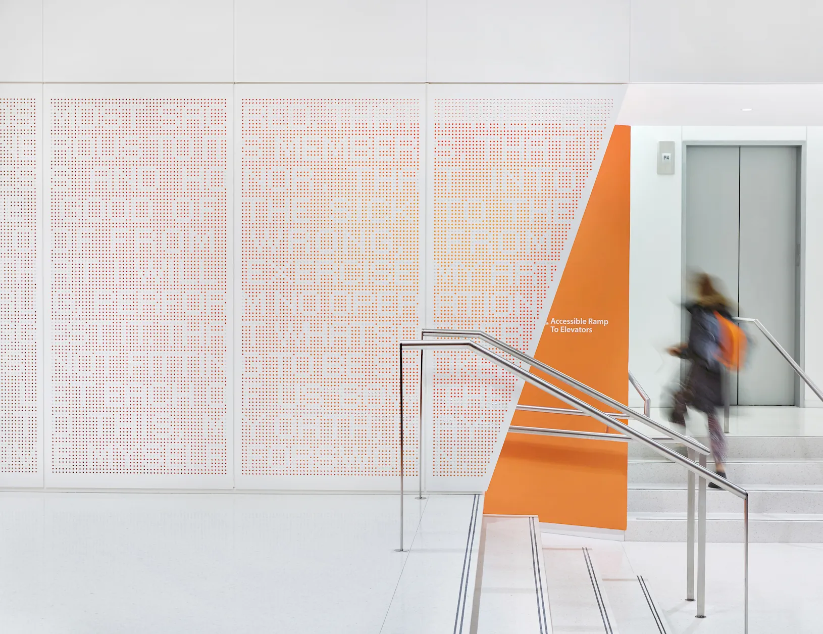 Entry lobby stair with perforated wall scrim of the text from the hippocratic oath