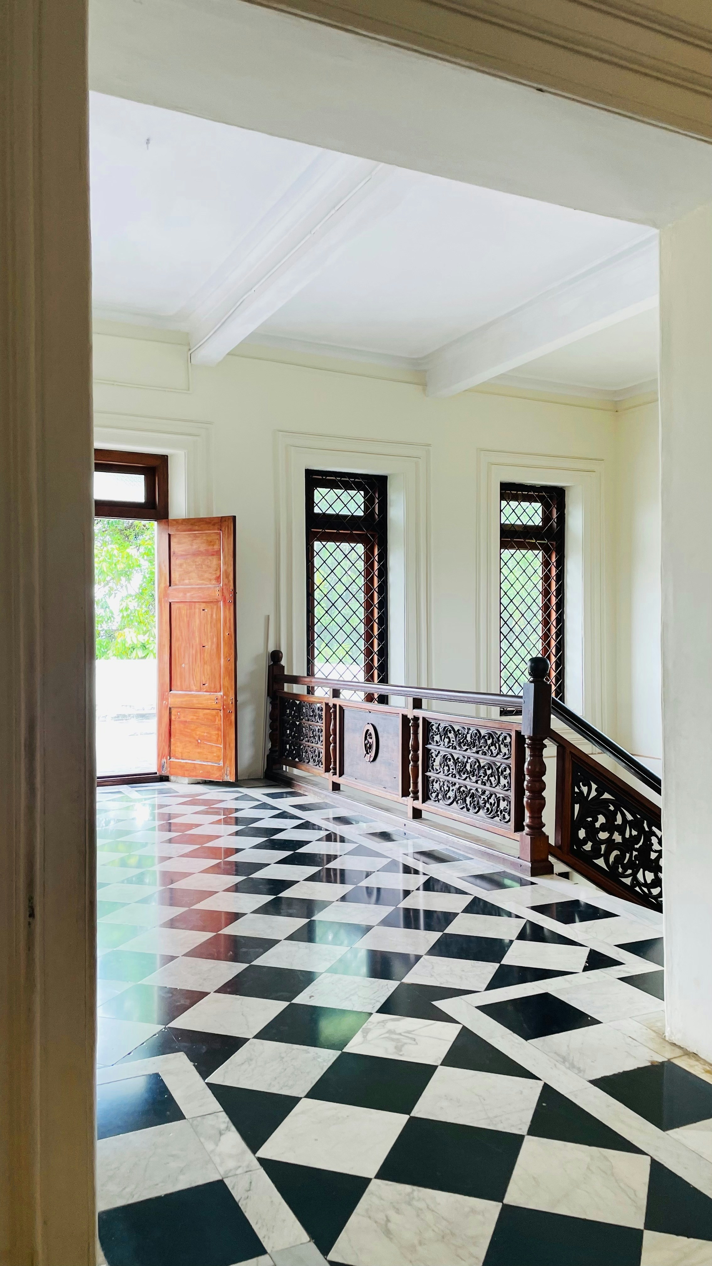 a room with a checkered floor and a wooden door