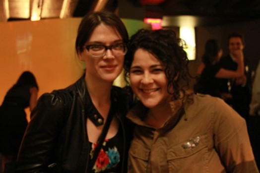 A photo of two women in a conference hall.
