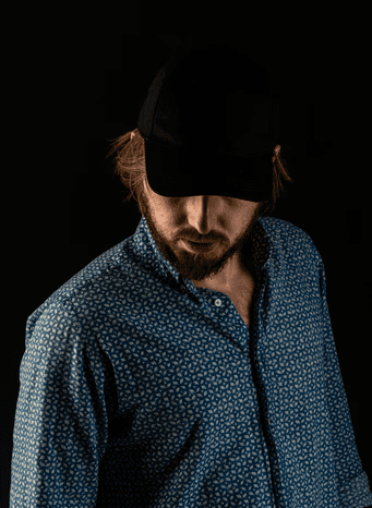 man in blue and white button up shirt wearing black cap