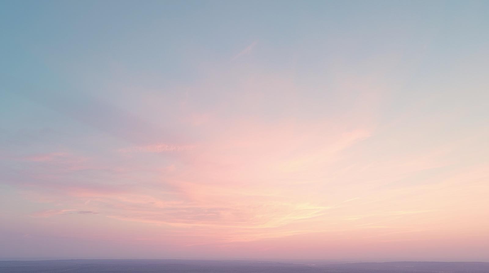 Pastel sunrise horizon with wispy clouds and warm morning light at dawn