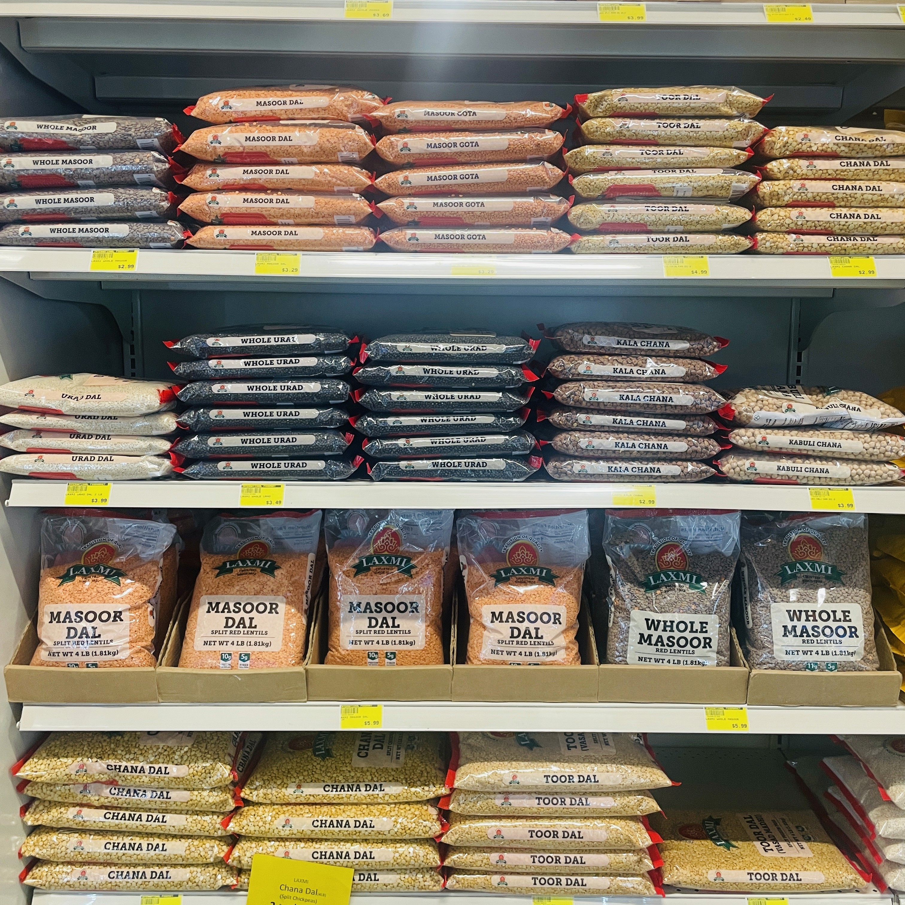 Shelves stocked with masoor dal and whole masoor lentils at International Food Market Orlando.