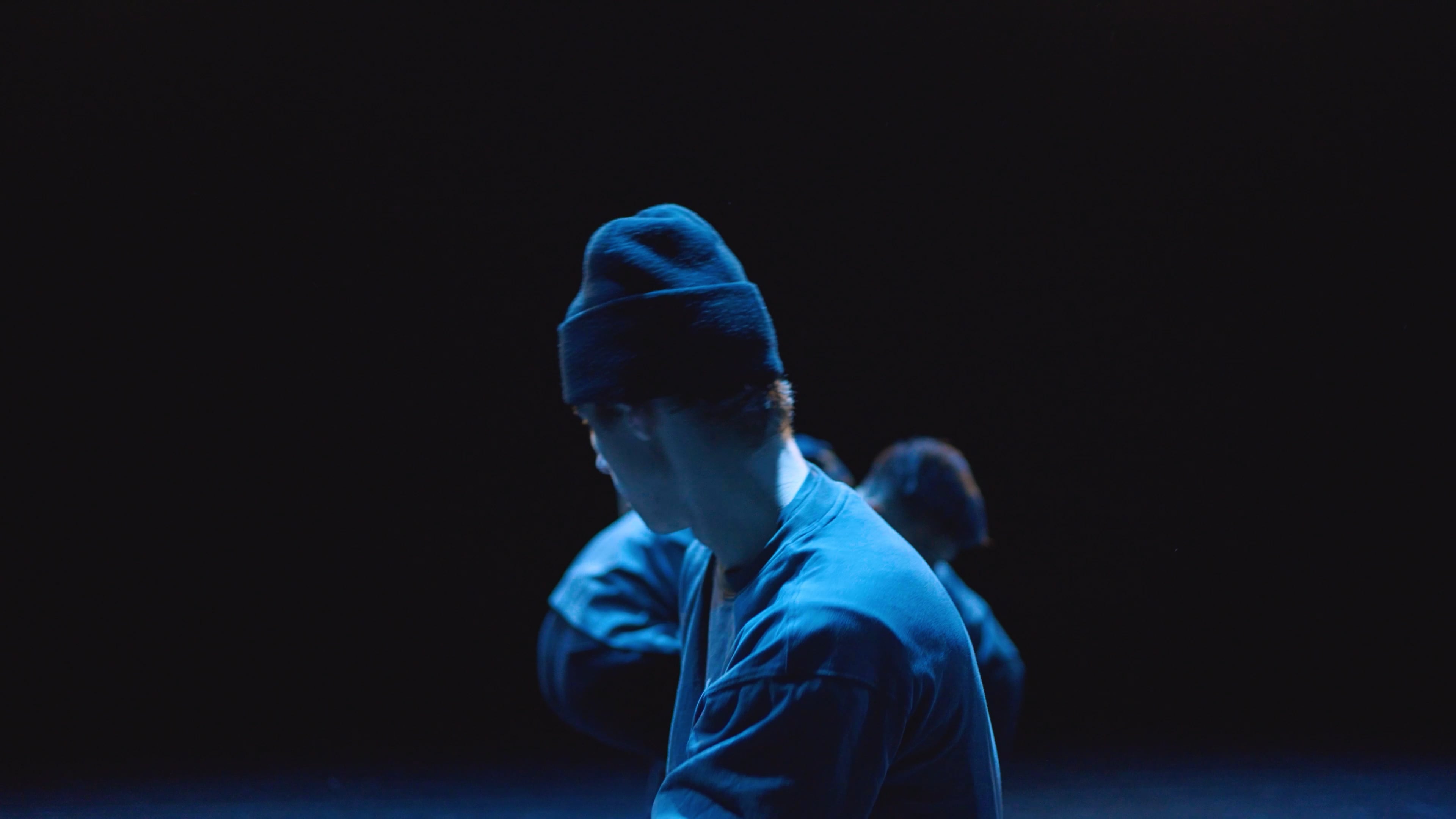 Man on stage looking up with hands in the ait