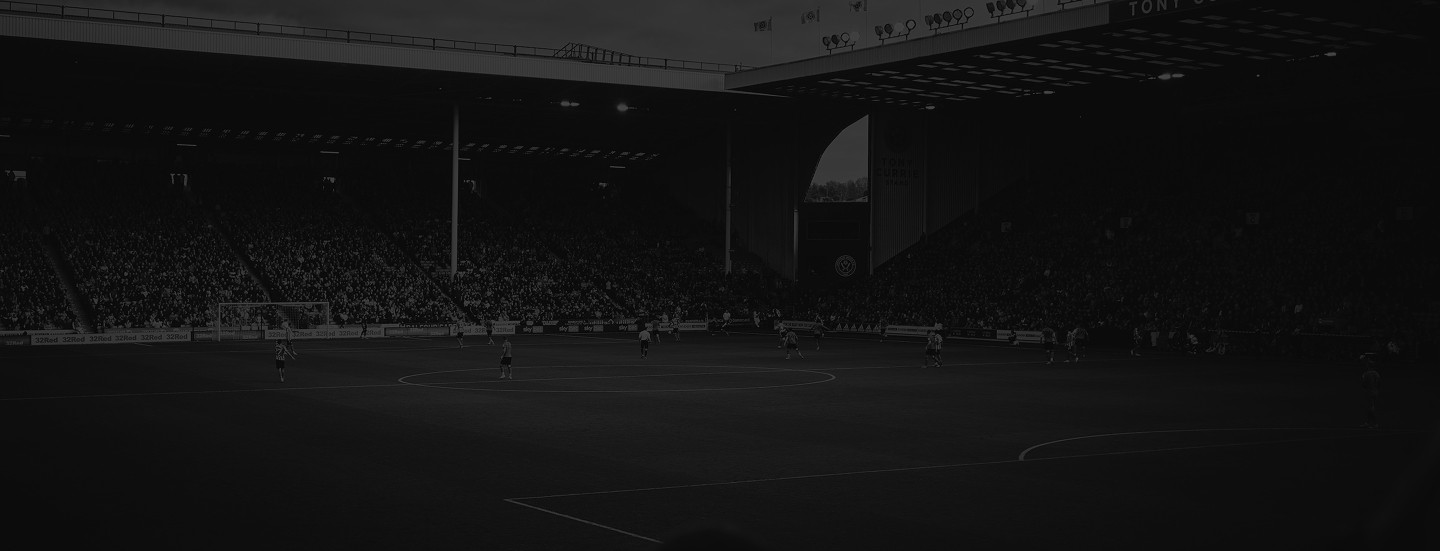 Un gran estadio lleno de espectadores bajo un cielo nublado alberga un emocionante partido de fútbol, ​​con jugadores participando activamente en el campo bien iluminado.