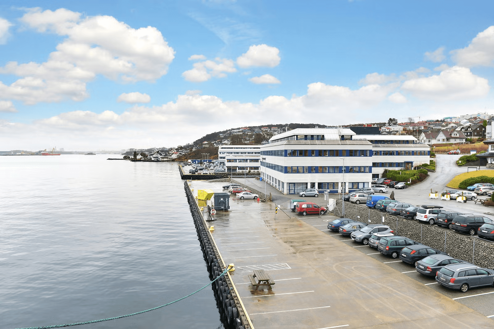 Eksteriør av næringsbygg og kontorlokaler ved sjøen på Skogstøstraen 37 i Stavanger med parkeringsplasser.