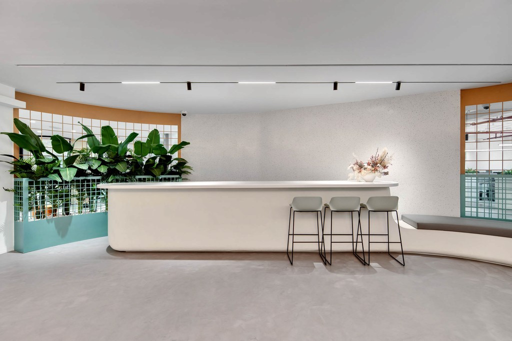 . A modern office space at The Binary by Omniyat featuring a stylish bar and lush indoor plants.