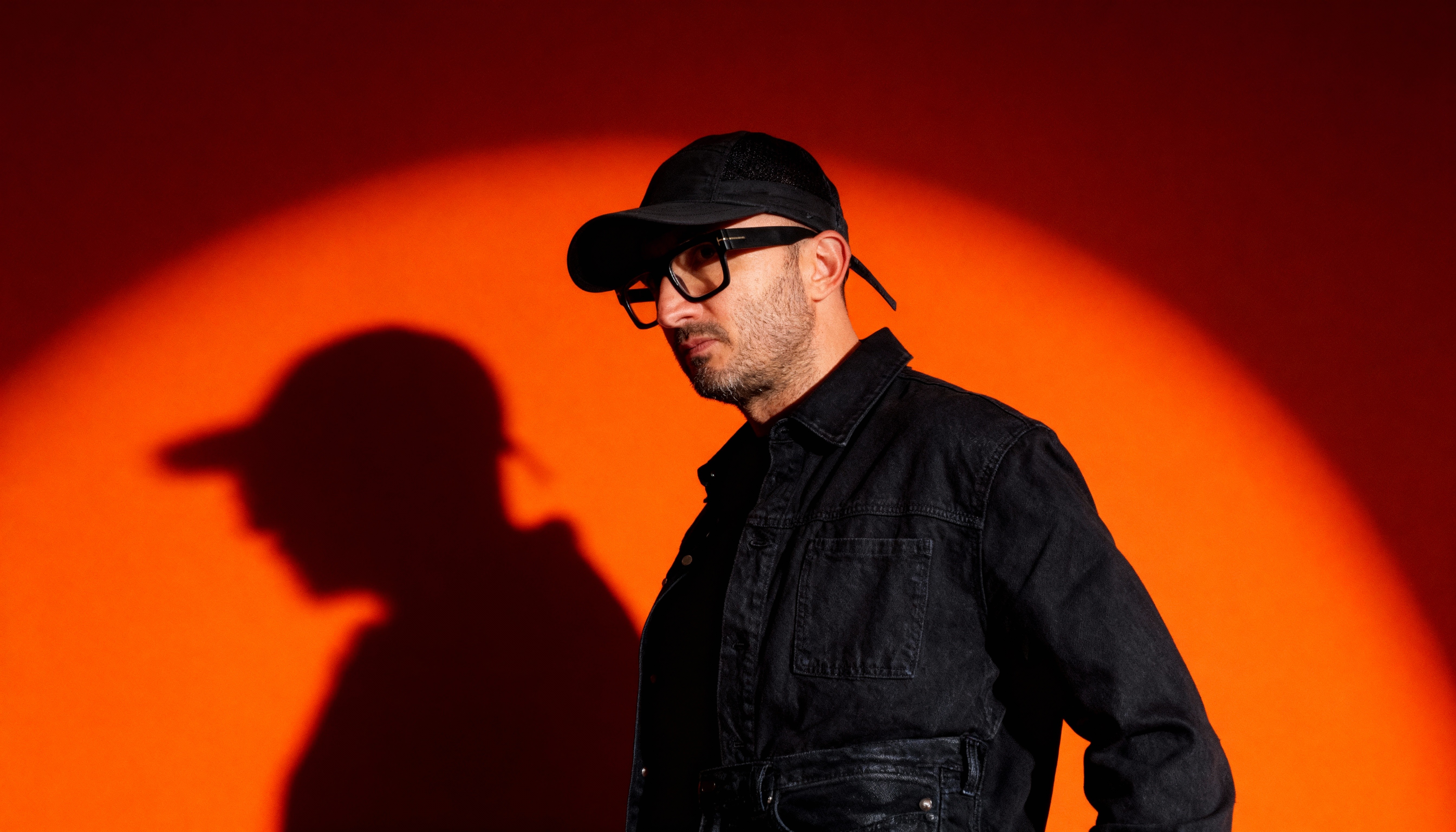Black and white image of people working at a table with laptops, showing hands gesturing during discussion of digital content displayed on screens, with fabrica® logo in the corner.