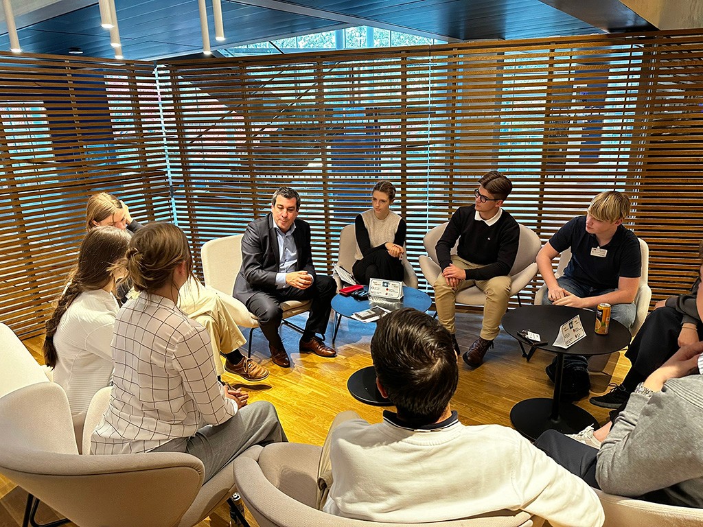Intensive Gruppendiskussion junger Talente bei der Debattenschmiede in moderner Lernumgebung.