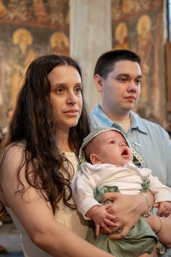 Părinții și copilul în timpul botezului ortodox.