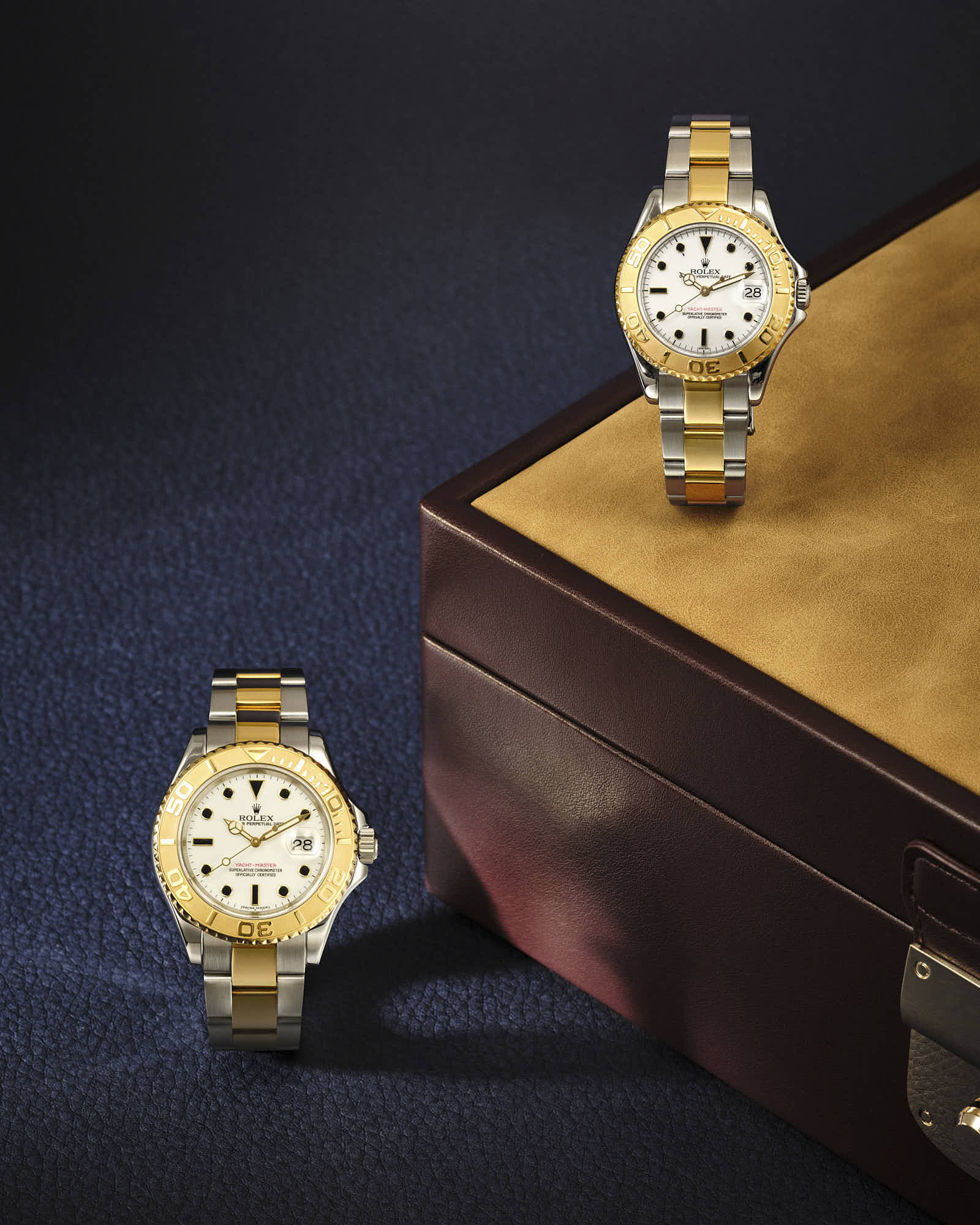 Luxury gold and silver wristwatches displayed elegantly on a leather surface.