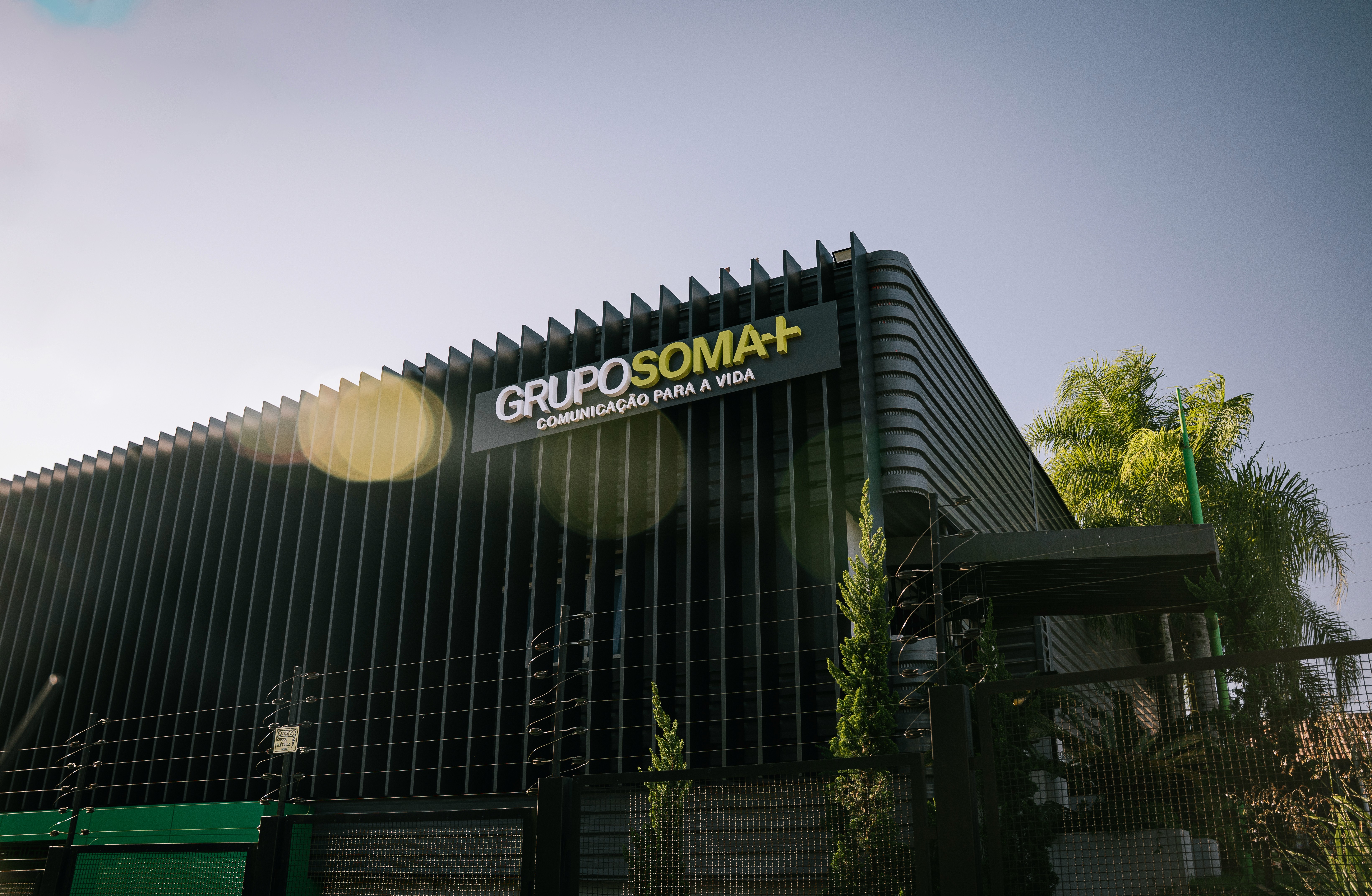 Close-up portrait of a person wearing a gray insulated hooded jacket with the hood up, showing their face framed by the hood against a light background.