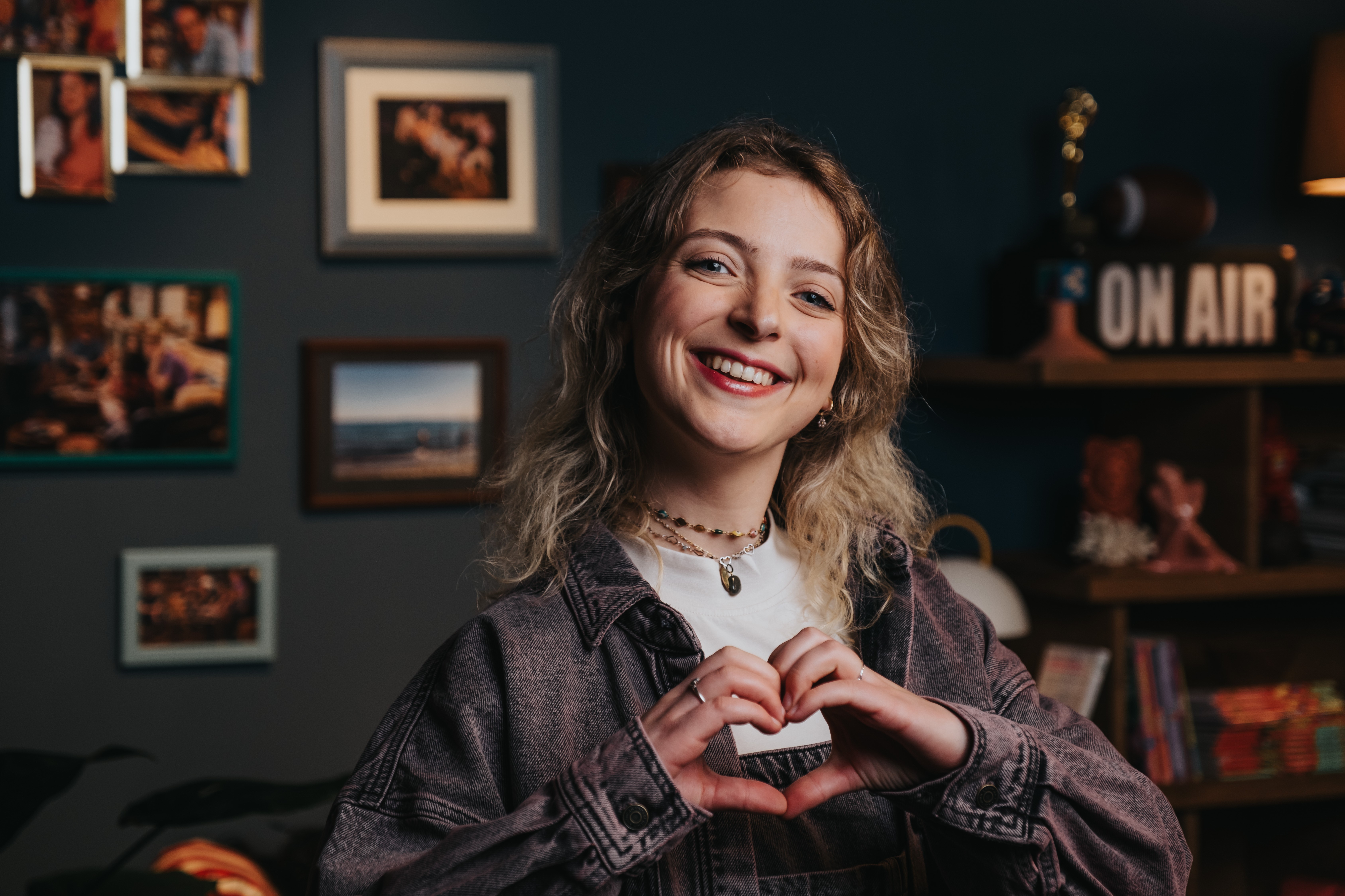 femme blonde qui fait un coeur avec ses mains