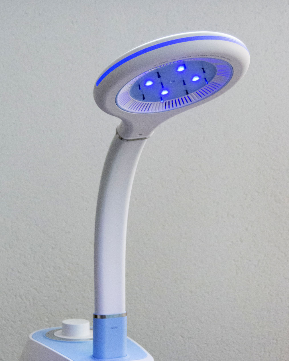 A smiling young man with crossed arms, wearing a plaid shirt and white t-shirt, poses against a dark background.