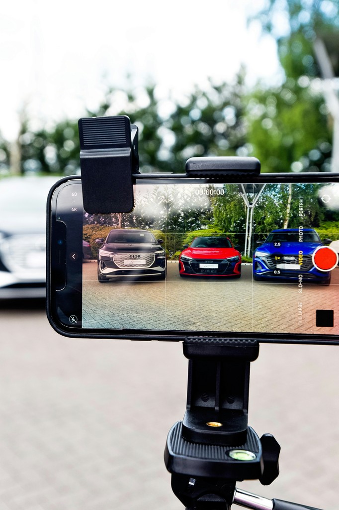 a person taking a picture of a car with a cell phone