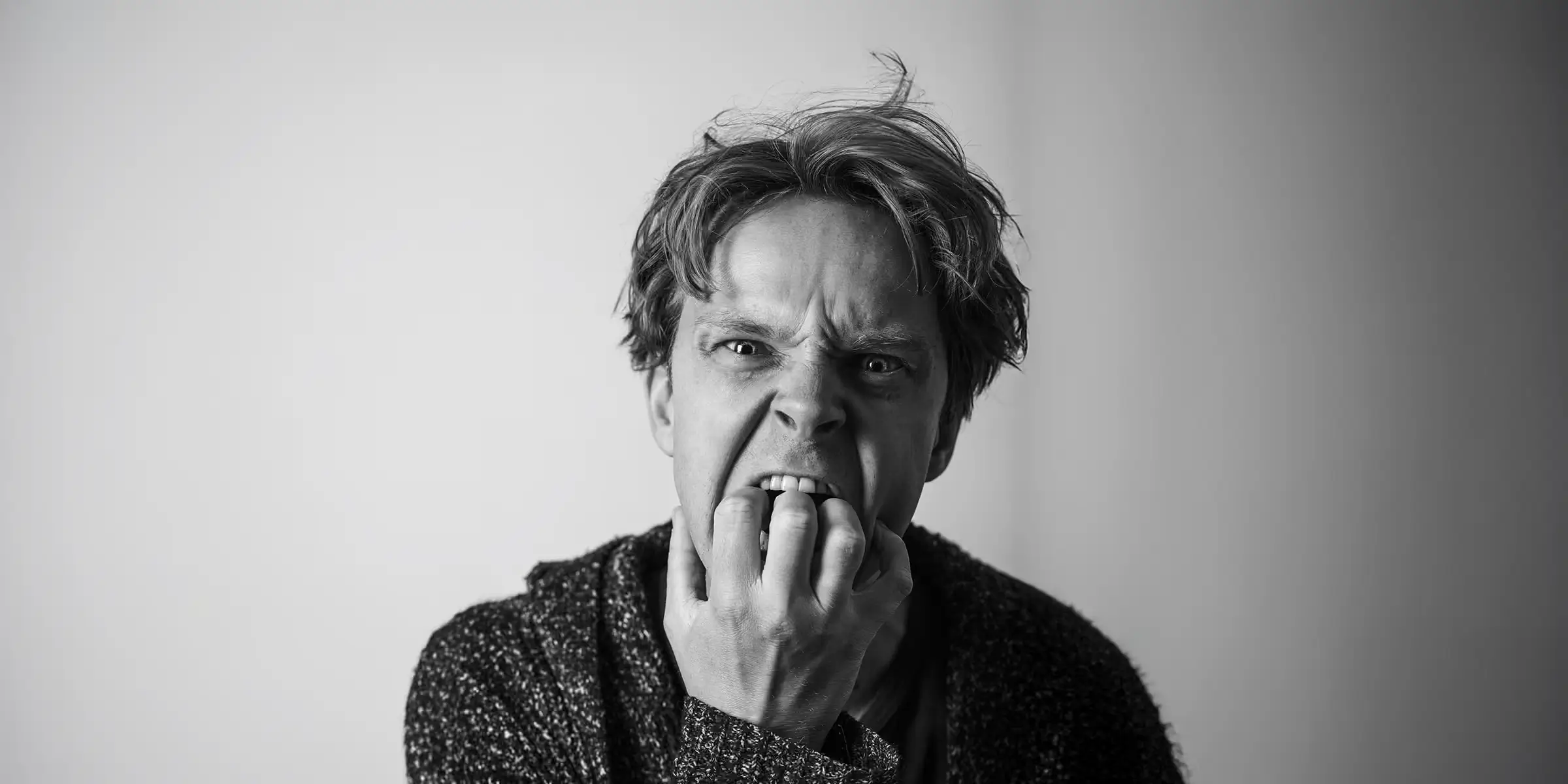 Close-up black and white portrait showing visible frustration, representing user anxiety caused by poor digital experiences.