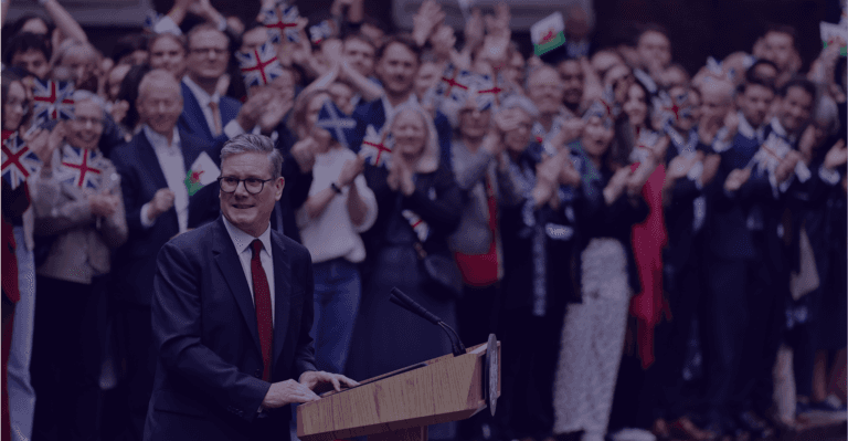 A person speaking at a podium surrounded by a large crowd at a public event or conference