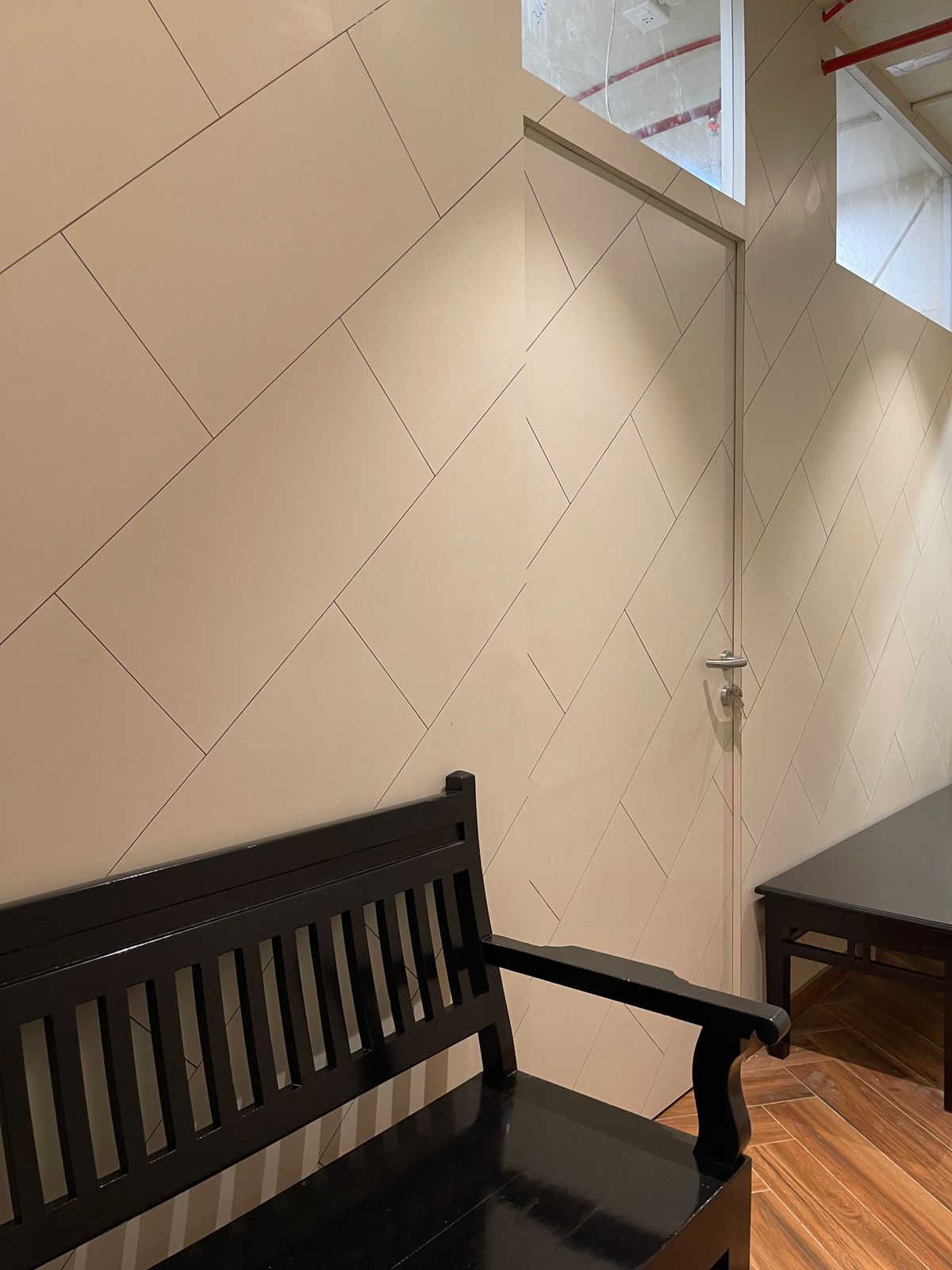 Nature-inspired preschool entrance with sculptural tree partitions and suspended green leaf ceiling panels.