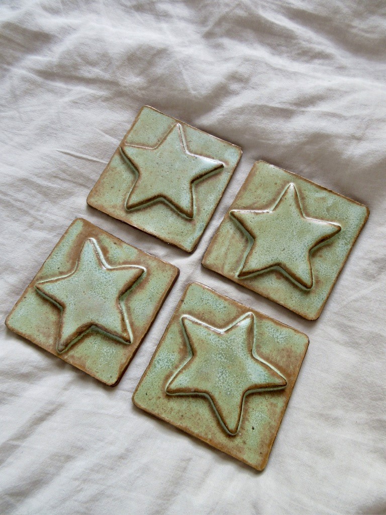 Six green star-shaped ceramic tiles