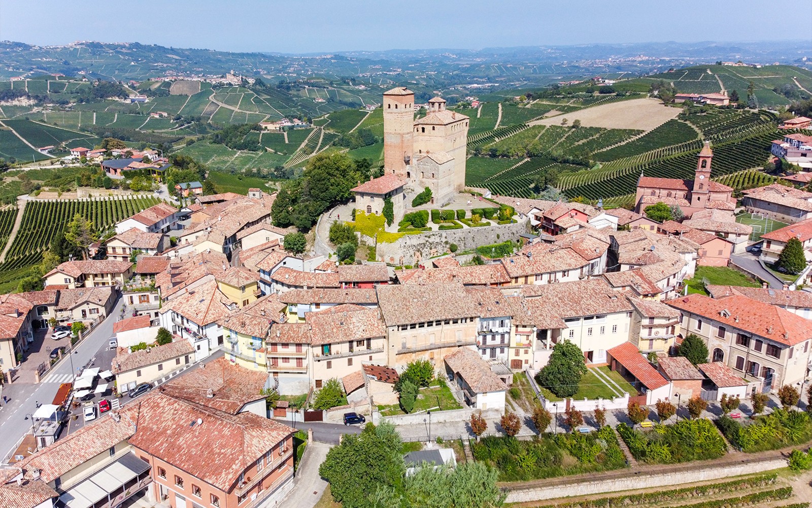 ทัศนียภาพทางอากาศของปราสาทเก่าแก่และหมู่บ้านในไร่องุ่นของแคว้นเปียมอนเต ประเทศอิตาลี